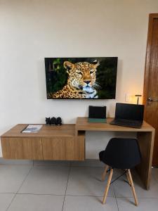 a desk with a picture of a leopard on the wall at D Castro Executive in Montes Claros