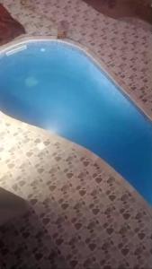 a swimming pool with a metal floor and blue water at Maison mazar in Bin Fatāʼil