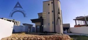 a large building with a sign on the side of it at Maison mazar in Bin Fatāʼil
