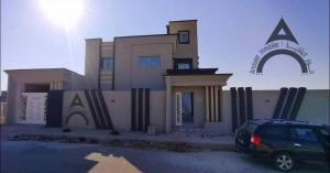 a building with a car parked in front of it at Maison mazar in Bin Fatāʼil