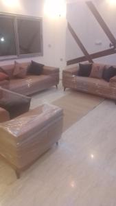 two brown leather couches in a living room at Maison mazar in Bin Fatāʼil
