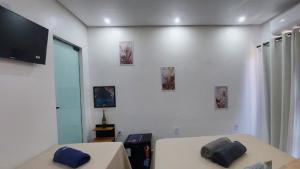 a bedroom with two beds and a flat screen tv at Suítes Rufino in Lençóis