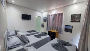 a bedroom with two beds and a mirror at Suítes Rufino in Lençóis +20 photos
