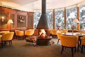 a lobby with a fireplace and tables and chairs at Hotel Yastrebets Wellness & Spa in Borovets