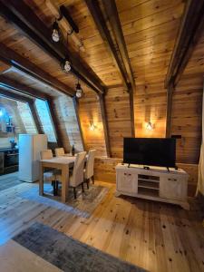 a living room with a table and a television in a cabin at Villa Evergreen Žabljak in Žabljak