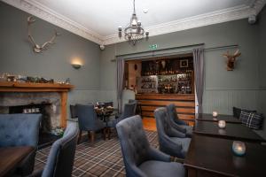 a restaurant with a fireplace and tables and chairs at The Courie Inn in Killin