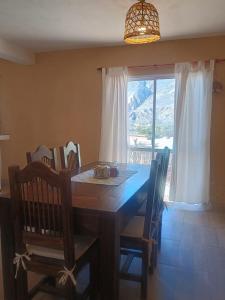 a dining room with a table and chairs and a window at Casa Las Pencas in Maimará