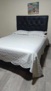 a large bed with a blue headboard in a bedroom at Casa Las Pencas in Maimará
