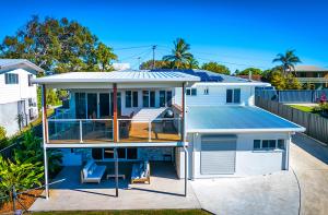 a house with a deck and a roof at Zilzie Beach House in Zilzie