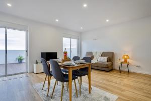 a living room with a table and chairs and a couch at Achadinha Sunset House - São Miguel, Açores in Achadinha