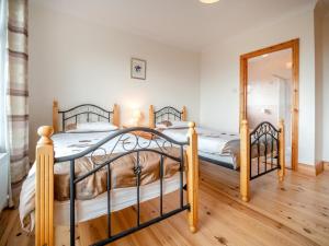 two twin beds in a bedroom with a mirror at 4 Bed in Inch oc-ii11636 in Caheracruttera