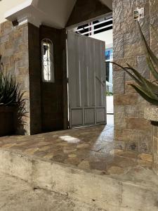 a door to a building with a stone wall at Habitación Mantarraya in Manta