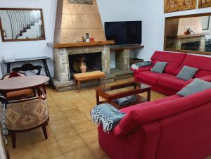 a living room with a red couch and a fireplace at Ca La Morancica in Yátova