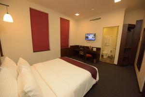 Hotel Nippon Colombo tesisinde bir odada yatak veya yataklar