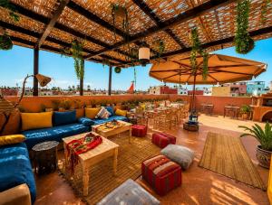 a patio with couches and tables and a large umbrella at Golden house in El Jadida