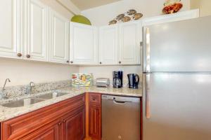 a kitchen with white cabinets and a stainless steel refrigerator at Villa 12 at Mara Laguna - Gold Standard Certified in San Pedro +49 photos