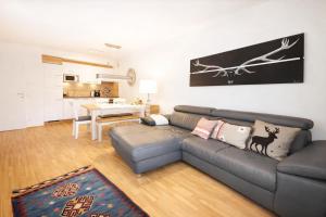 a living room with a couch and a kitchen at Alpinum Residence Lungau Ferienwohnung mit Garten in Tamsweg