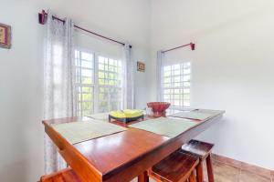 a dining room with a wooden table and two windows at La Rana in San Ignacio +24 photos