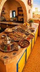a buffet with many plates of food on a counter at Golden house in El Jadida +8 photos