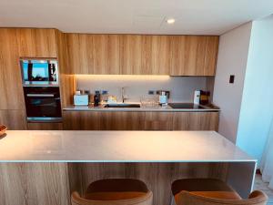 a kitchen with wooden cabinets and a counter top at Surfside - 3 Suítes - 4 Bathroom in Punta del Este