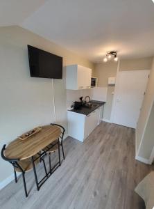 a living room with a table and a kitchen at Studio Havane avec clim in Bourbonne-les-Bains