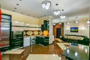 a large kitchen with black cabinets and a living room at Kolorit Modern Apartment in Baku