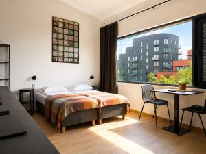 a hotel room with a bed and a large window at Filosoofi Suites in Tartu