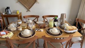 a wooden table with plates and dishes on it at Atins Brisa in Barreirinhas +4 photos