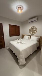 a bedroom with a large white bed with a heart on it at Atins Brisa in Barreirinhas