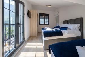 ein Schlafzimmer mit zwei Betten und einem großen Fenster in der Unterkunft Amalia in Donji Morinj + 88 Fotos