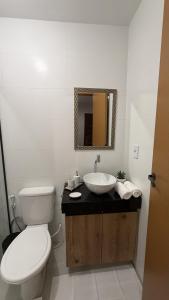 a bathroom with a toilet and a sink with a mirror at Atins Brisa in Barreirinhas