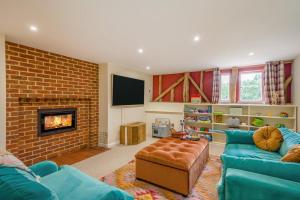a living room with a blue couch and a brick fireplace at 6 Bed in Ardleigh oc-b35089 in Ardleigh