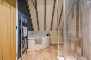 a bathroom with a tub and a glass shower at 6 Bed in Ardleigh oc-b35089 in Ardleigh +48 photos