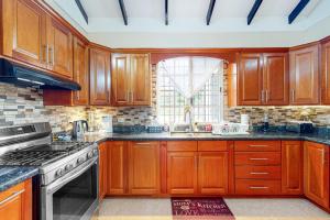 a kitchen with wooden cabinets and a window at The Pine Tree Villa in San Ignacio +13 photos