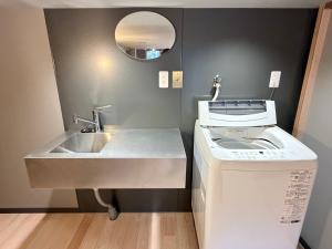 a bathroom with a sink and a washing machine at KUMANOYASAI Cottage in Chikatsuyu in Tanabe +36 photos