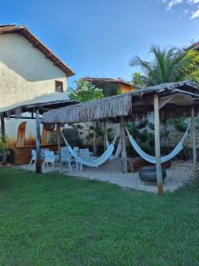 a resort with hammocks and umbrellas in a yard at NaPraia Brasil Pousada in São Miguel do Gostoso