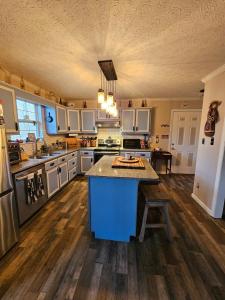 a large kitchen with a blue island in the middle at Rowan's Mountain View in Powell