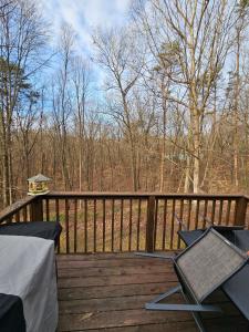a deck with chairs and a table and a bird house at Rowan's Mountain View in Powell