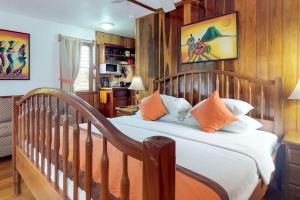 a bedroom with a wooden bed with orange and white pillows at Latitude Adjustment Gold Standard Certified in Hopkins