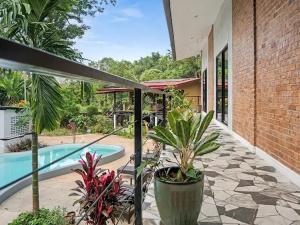 an outdoor patio with a swimming pool and plants at Para Hill Homestay in Ban Muang Mai