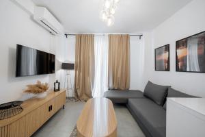 a living room with a couch and a table at Ambra Luxury Suite 18 in Kallithea Halkidikis