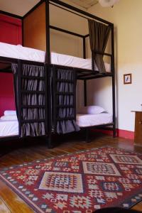 two bunk beds in a room with a rug at La Casa Rosada Hostel in Jericó