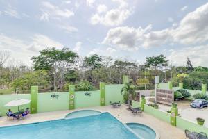 a pool at a resort with people sitting around tables at Suite Junior at Midas Belize in San Ignacio