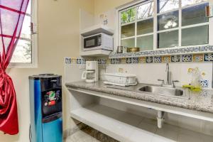 a kitchen with a sink and a microwave at Suite Junior at Midas Belize in San Ignacio