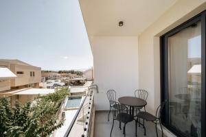 a balcony with a table and chairs on it at Ambra Luxury Suite 18 in Kallithea Halkidikis