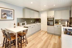 a kitchen with white cabinets and a table and chairs at 3 Bed in Bassenthwaite oc-lr197 in Bassenthwaite