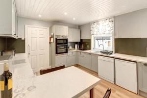a kitchen with white cabinets and a table in it at 3 Bed in Bassenthwaite oc-lr197 in Bassenthwaite +16 photos
