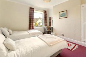 a bedroom with two beds and a window at 3 Bed in Bassenthwaite oc-lr197 in Bassenthwaite