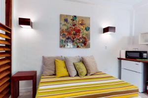 a couch in a room with a painting on the wall at Rainforest Suite at Casa DV Suites -Gold Standard Certified in Caye Caulker