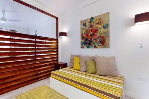 a room with a couch and a painting on the wall at Rainforest Suite at Casa DV Suites -Gold Standard Certified in Caye Caulker